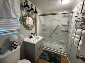 Een douche, handdoeken, zeep, toiletpapier