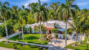 A residential area with a house, palm trees, and a clear sky. - Sedona Style Resort home awaits your company! (Fort Myers)