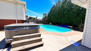 A backyard with a swimming pool, a hot tub, and a wooden deck. - Private Bachelor Unit close to St. Clair College walking distance  (Windsor)