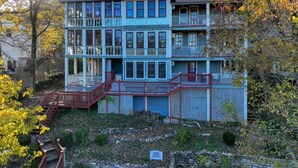 A multi-story building with a balcony on the second floor, surrounded by trees with autumn foliage. - Downtown Edgewood Terr Piedmont (Eureka Springs)