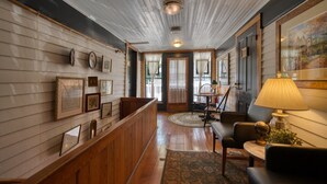 A room with wooden paneling, a dining area with a table and chairs, and a lamp. - Downtown Magnolia Ste Piedmont (Eureka Springs)