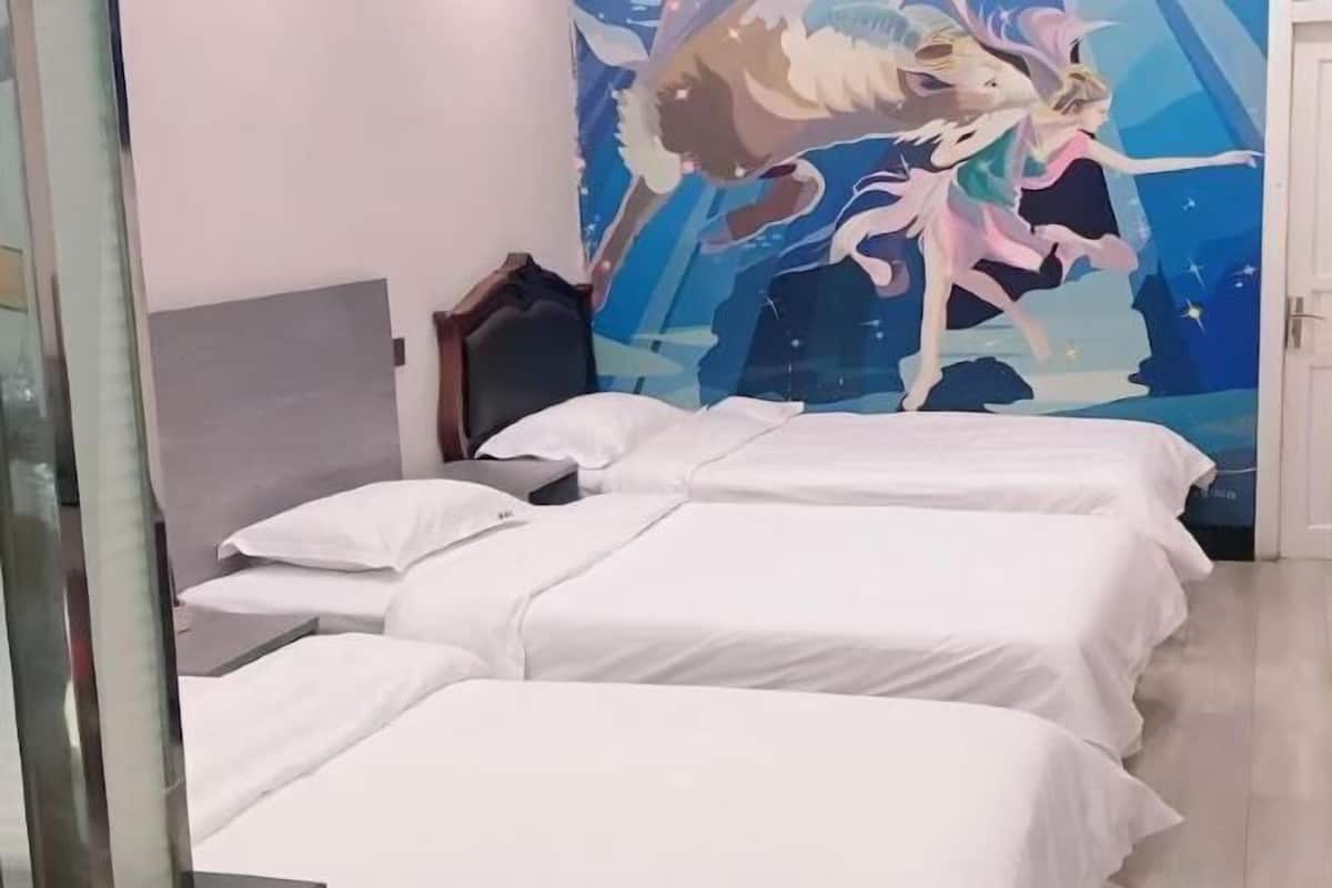 Habitación de hotel con tres camas individuales, un mural grande en la pared y un cabecero de madera.