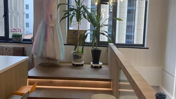 A modern interior with a wooden staircase, a dining area with yellow chairs, and potted plants. - Pandora Fashion Hotel (Yanji Yanbian University West Market Branch) (Yanji)