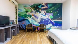 A hotel room with a large mural, a bed, a TV, and a desk with chairs. - Pandora Fashion Hotel (Yanji Yanbian University West Market Branch) (Yanji)