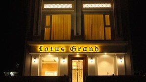 Un edificio con un letrero que dice 'Lotus Grand' por la noche.