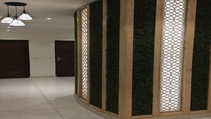 Habitación con separador de esquina que presenta paneles de madera verticales y un diseño de celosía.