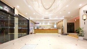 A hotel lobby with a reception desk, glass doors, and a tiled floor. - Taihe Kaida Business Hotel (Taihe People's Hospital) (Taihe)
