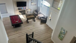 A spacious living room with a pool table, foosball table, and a comfortable seating area. - Charming 4-bedroom house in enchanting Las Vegas!  (Las Vegas)