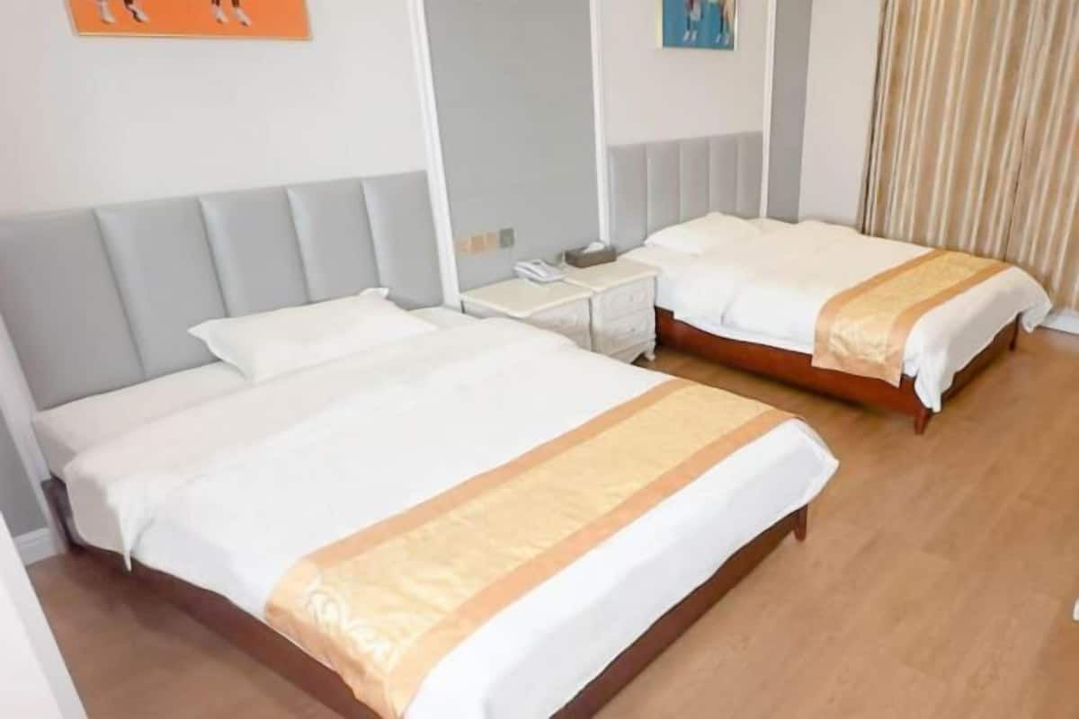 Une chambre d’hôtel avec deux lits, une table de chevet et un miroir.
