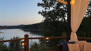 Eine Terrasse mit Feuerstelle, Sitzgelegenheit und Seeblick.