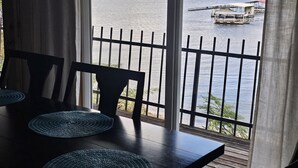 Un espace repas avec vue sur un lac et un quai.