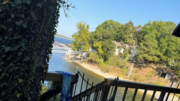 Un bain à remous sur une terrasse en bois, avec vue sur une rivière et des arbres.