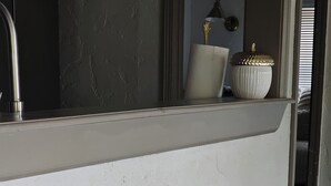 Un coin bar avec trois tabourets et un miroir au-dessus.