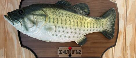 A mounted fish labeled "Big Mouth Billy Bass" on a wooden board.