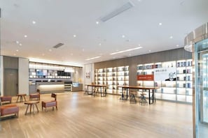 A modern library with bookshelves, tables, and chairs. - HanTing Hotel (Cixi Longshan) (Cixi)