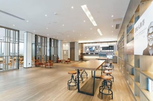 A spacious interior with a long counter, bar stools, and a kitchen area.