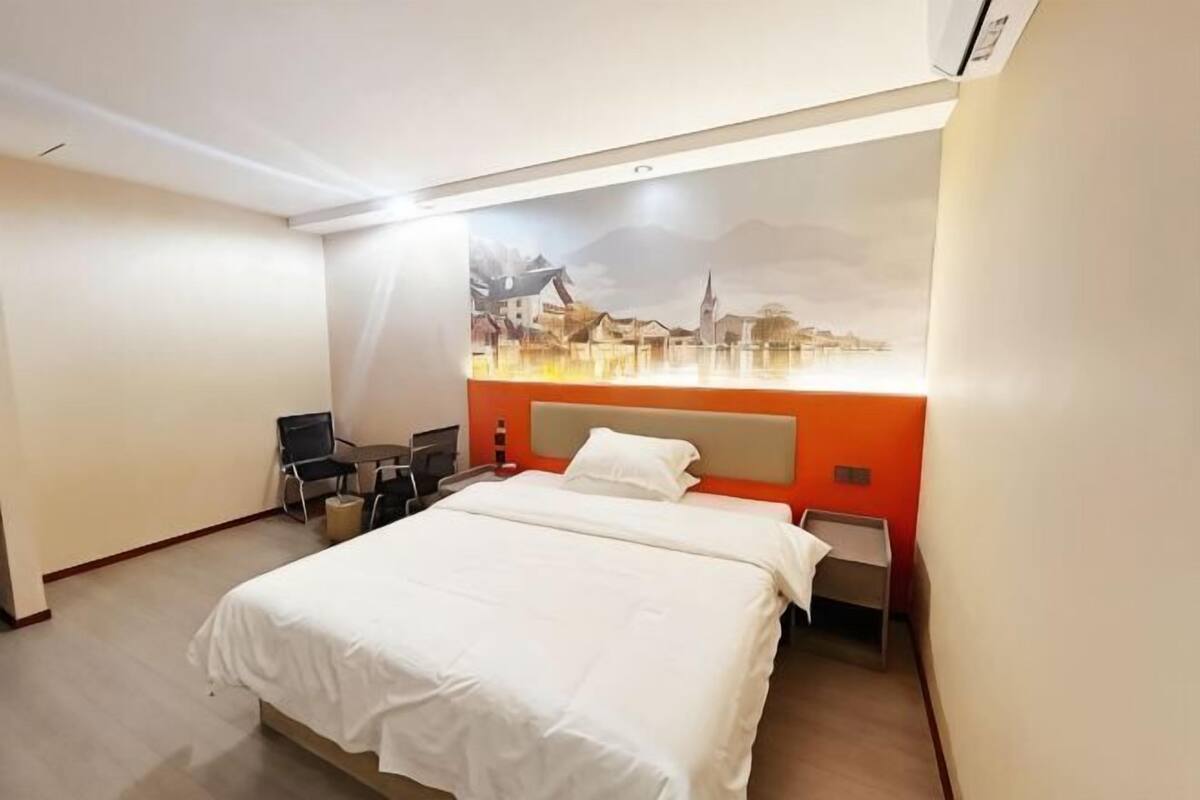 A hotel room with a bed, a desk, and a chair.