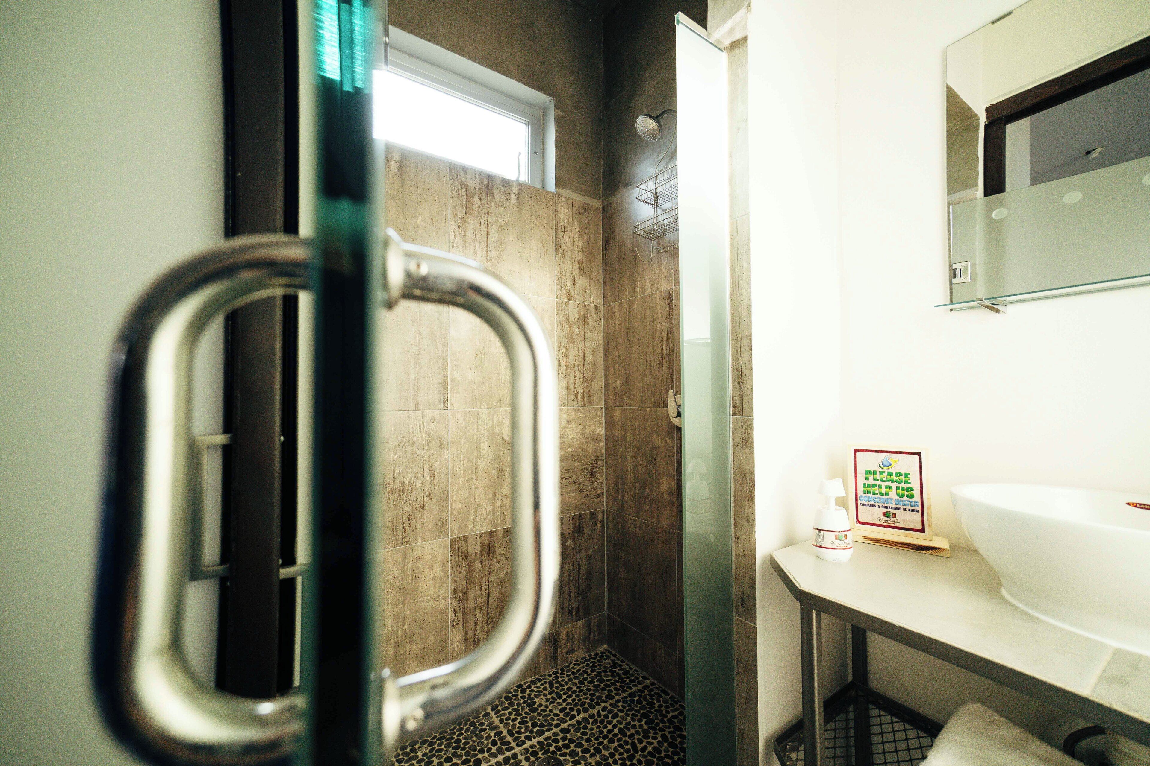 A bathroom with a shower, a sink, and a mirror.
