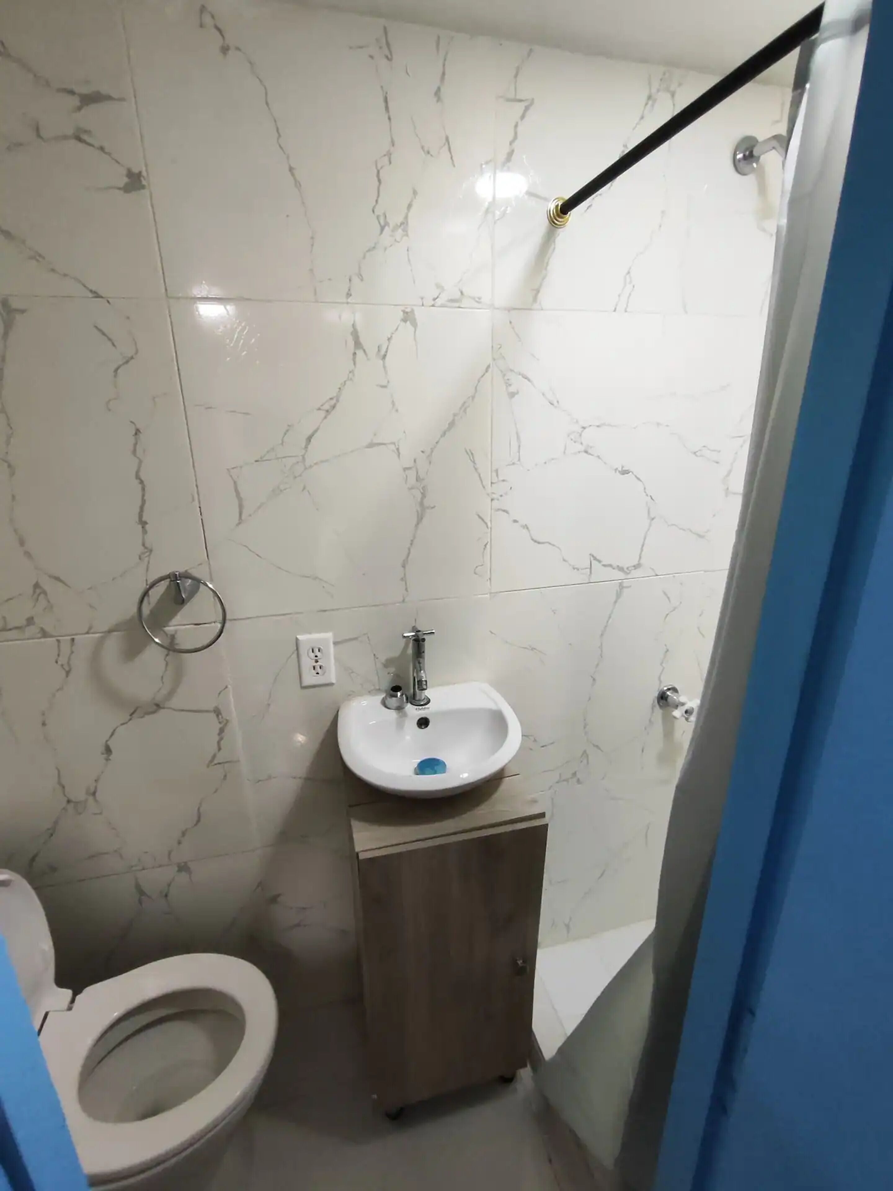 Un baño con inodoro, lavabo y zona de ducha.