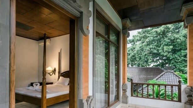 Une chambre avec un lit, une fenêtre et un balcon.
