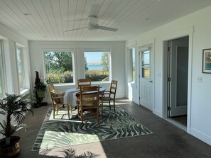 A dining area with a table and chairs, large windows, a ceiling fan, and a view of the outdoors. - Entire home in Valier, Montana (Valier)