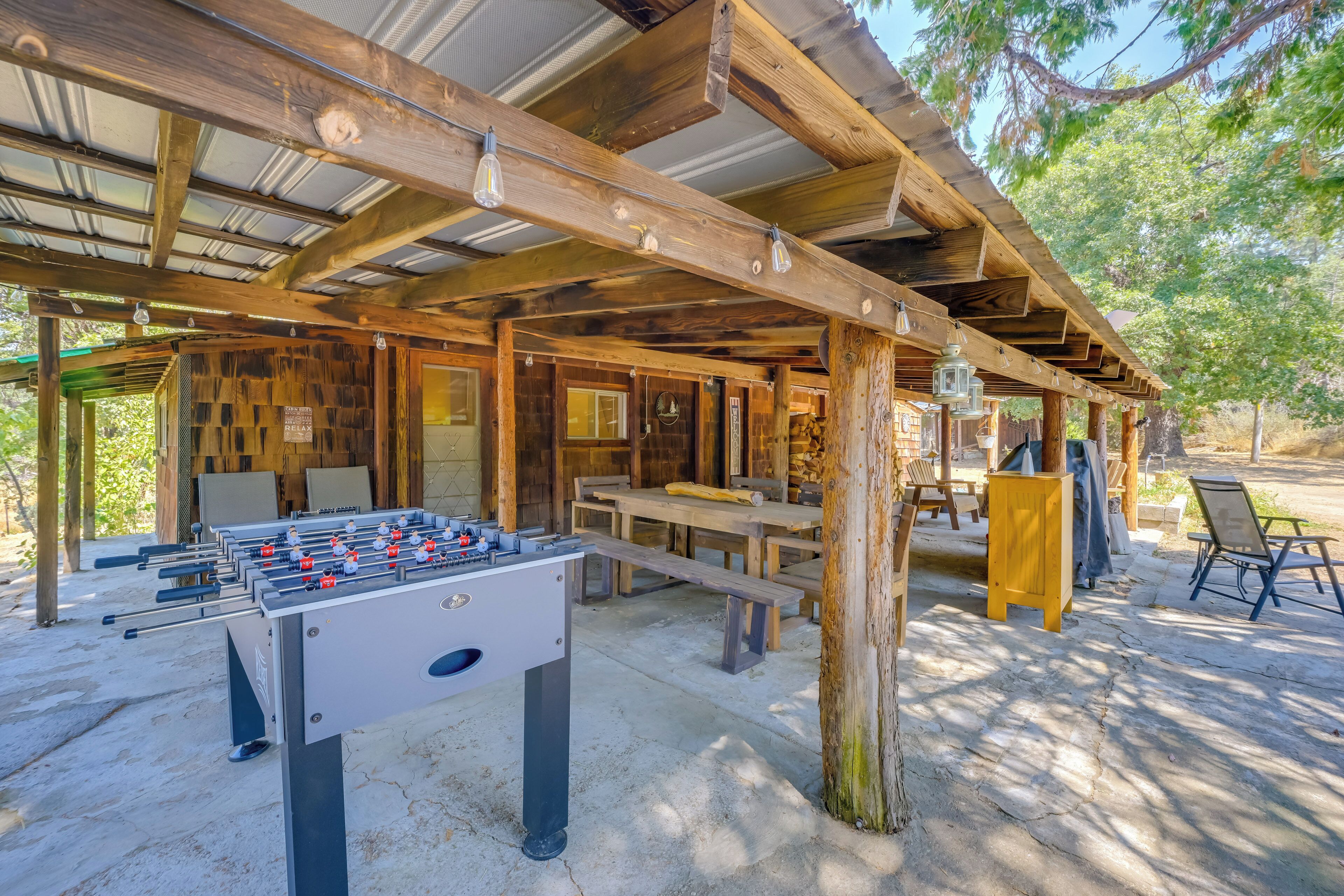 Eine hölzerne Außenkonstruktion mit Tischfußball, Picknicktischen und Bänken.