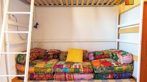 Ein Etagenbett mit bunten Quilts und einem gelben Kissen.