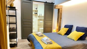 Een keurig opgeruimde slaapkamer met een bed, een houten ladder en een wandplank.