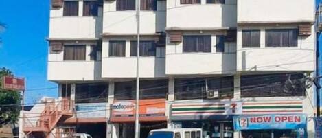 Um edifício de vários andares com uma loja de conveniência 7-Eleven no andar térreo.