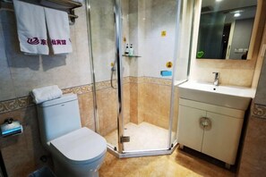A bathroom with a toilet, a shower enclosure, a sink, and a mirror. - Homeinn Pebble Hotel (Shengzhou Shengzhou Avenue Kaiyuan Plaza) (Shengzhou)