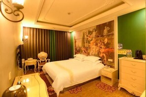 Camera d'albergo con un letto, comodini, una cassettiera, una sedia, una scrivania e una parete verde.