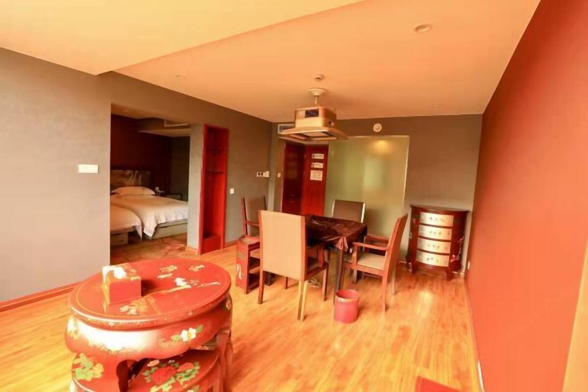 Una camera d'albergo compatta con un letto, un piccolo tavolo e angolo cottura.