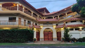 A multi-story hotel with a traditional architectural style, featuring balconies and a prominent entrance with a large wooden door. - Hotel Pacific Pearl (Punta Mala)