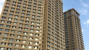 A high-rise building with a grid of windows and a curved corner design. - Dalian Huafa New Town Hotel Apartment (Dalian)