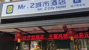 Un cartel de hotel con el nombre 'Mr. Z City Hotel' y un letrero de estacionamiento debajo.