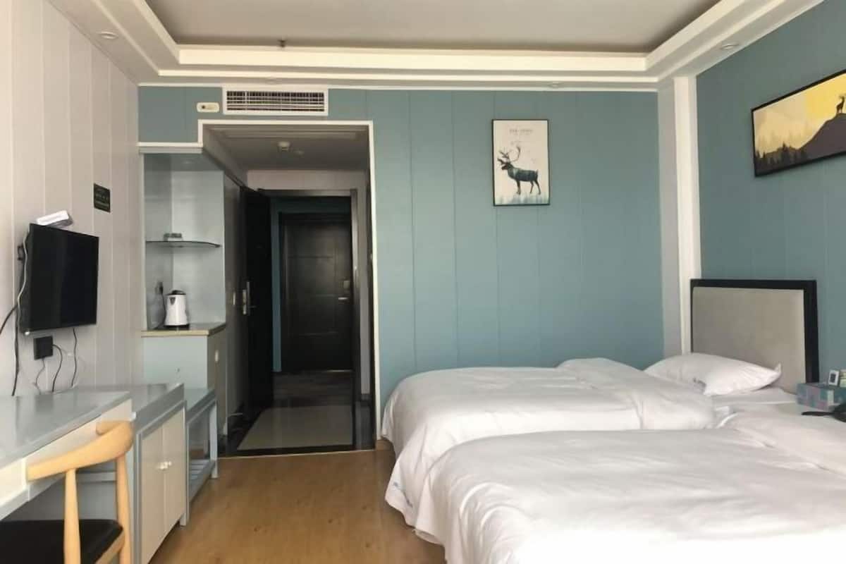 Une chambre d’hôtel avec un lit, un bureau, une chaise et un téléviseur.