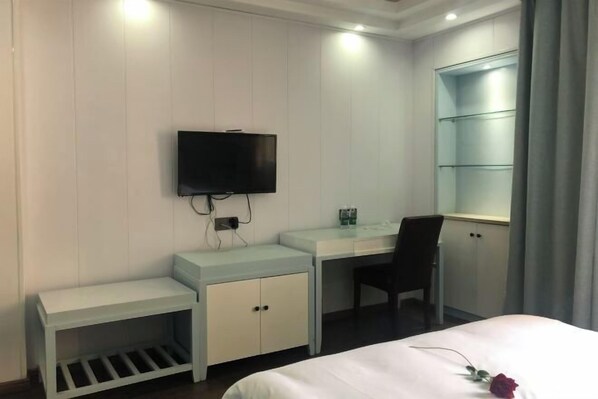 A hotel room with a bed, a desk, a chair, a TV, and a wardrobe. - Mr.z City Hotel, Xiangyang (Poyang)