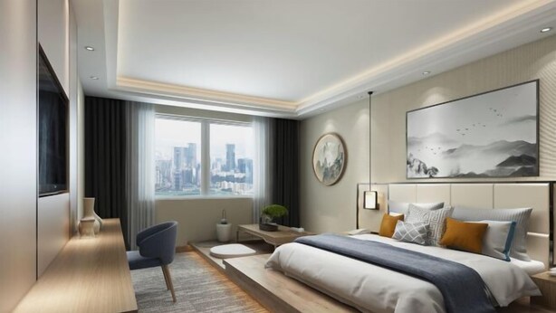 Una habitación de hotel moderna con una cama grande, un escritorio y vistas al horizonte de la ciudad.