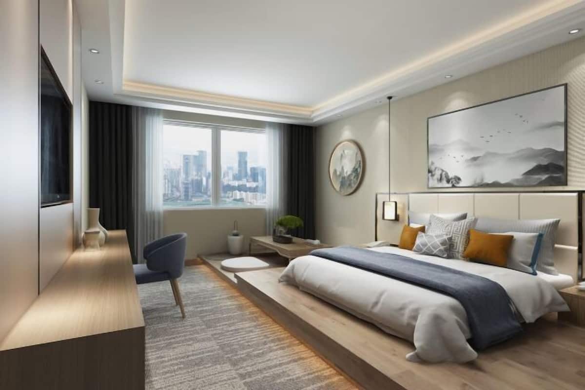 Une chambre d’hôtel moderne, dotée d’un grand lit, d’un bureau et offrant une vue sur le panorama urbain.