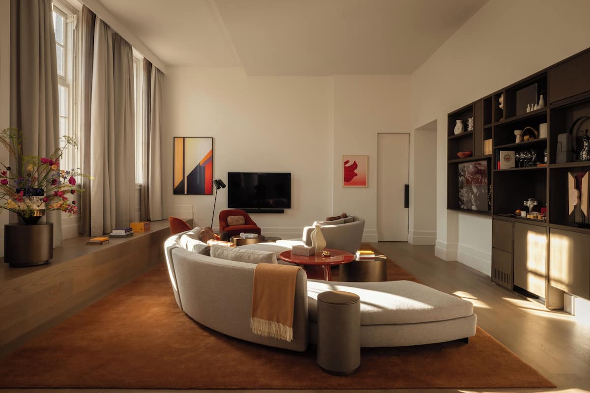 A modern living room with a sectional sofa, a coffee table, and a bookshelf.