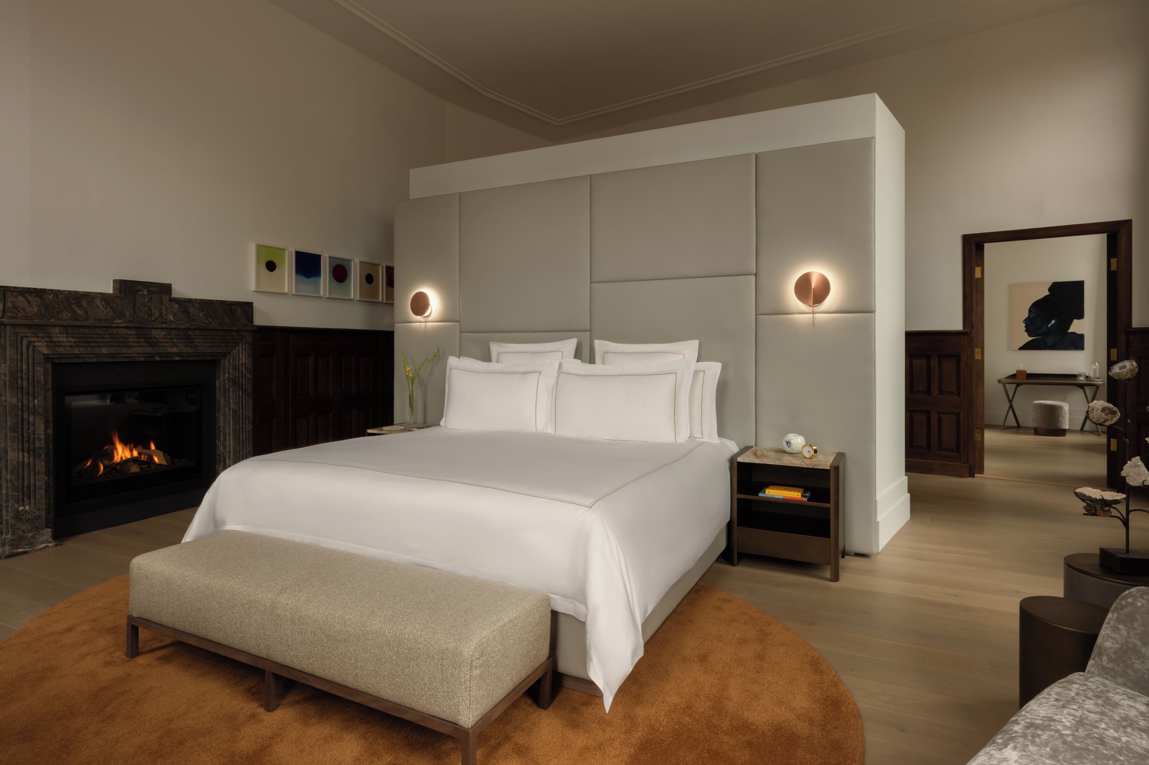Ein modernes Schlafzimmer mit einem großen Bett, einem Kamin und einem Nachttisch.