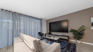 Ein modernes Wohnzimmer mit einer Couch, einem Couchtisch, einem Fernseher und einer Wand mit Muster.