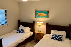 A hotel room with two beds, a nightstand with a lamp, a painting on the wall, and a window with blinds. - Coral Vista-Tesla Charger 3 Br  w Pool Canal (Cape Coral)