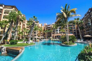 Ein Resort mit mehreren Schwimmbecken, Palmen und mehrstöckigen Gebäuden.