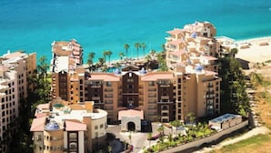 A hotel with multiple floors, a central courtyard, and a beach view. - Spectacular 2BD Beachfront Condo in Villa del Arco
 (Cabo San Lucas)