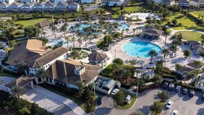Vista aérea de um resort com várias piscinas, um estacionamento e um clube.