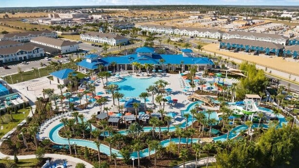 Vista aérea de un complejo turístico con varias piscinas, palmeras y edificios del complejo.