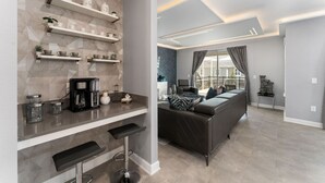 A modern kitchen with built-in shelves, a coffee machine, and a bar area. - 6BD InstaWorthy home pool cine and BBQ near Disney (Davenport)