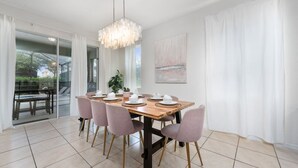 Comedor con mesa de madera, seis sillas y una araña.