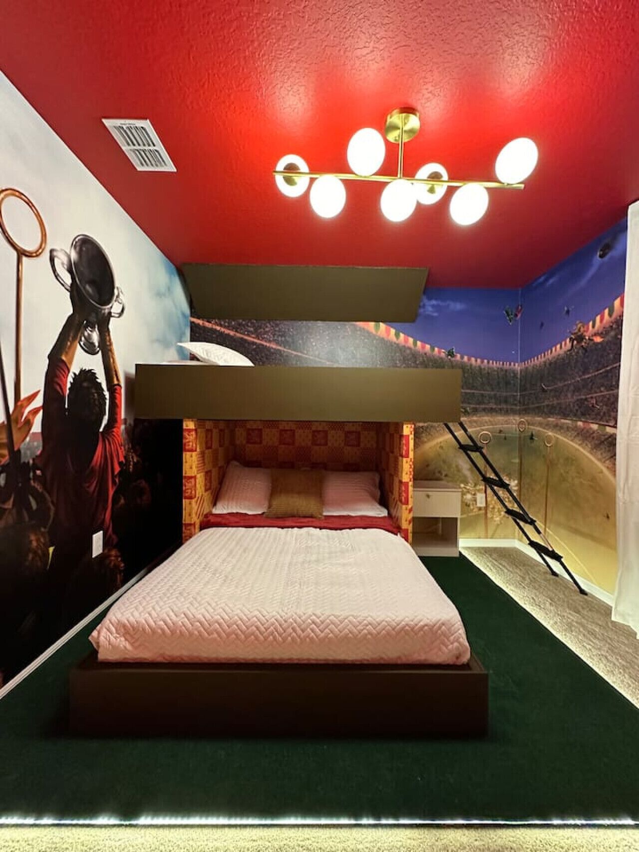 Una camera da letto con un letto, un murale, un soffitto rosso e un design originale.
